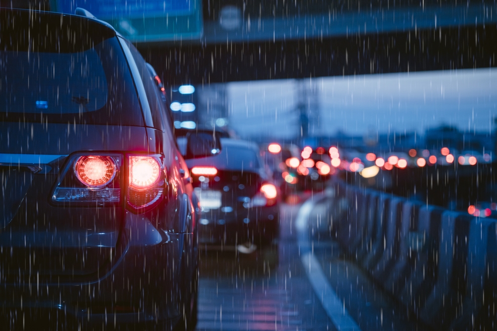 Traffic with brake lights on a highway in the rain at dusk