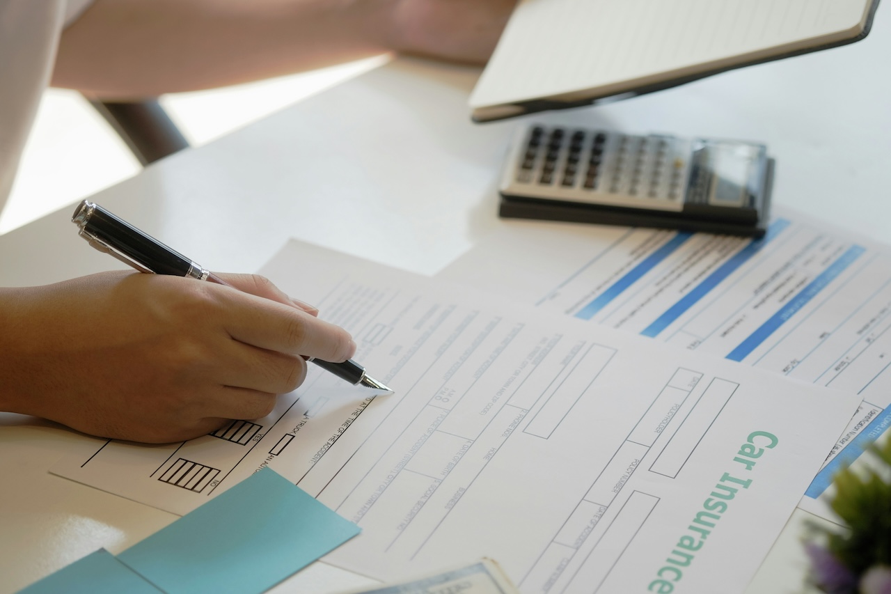 a person filling out a car insurance claim form