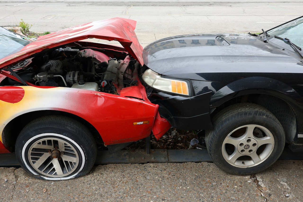 a black car and a red car after a head-on collision