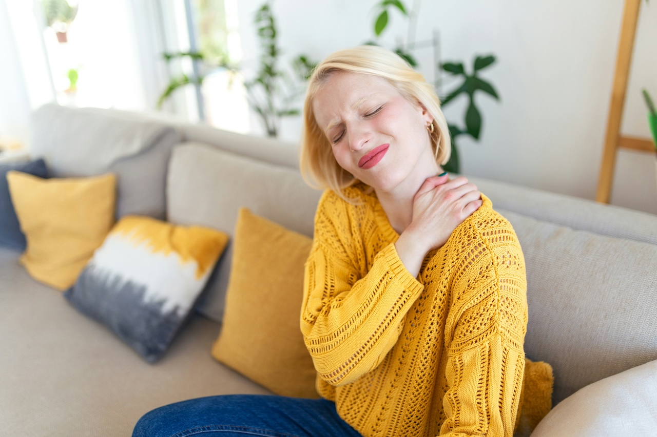 a woman holding her neck in pain