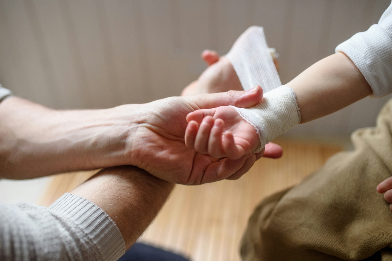 a person bandaging another's arm
